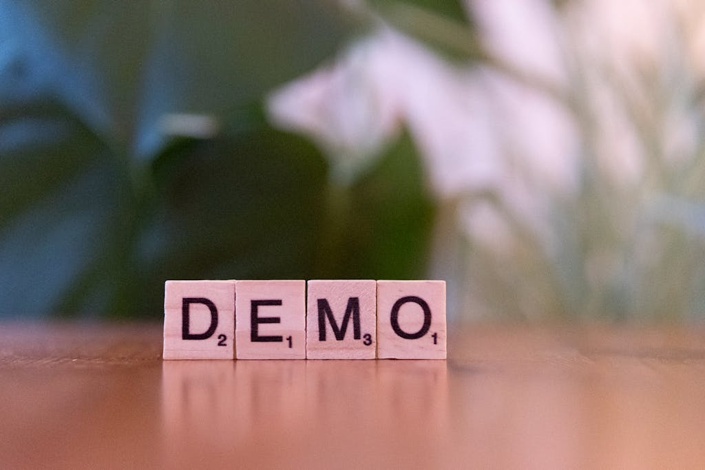 Close-up of wooden letter tiles spelling 'DEMO' on a blurred background, showcasing simplicity.